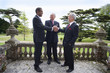 Businessmen shaking hands on balcony of manor house