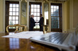 Laptop computer and paperwork on table, businessmen shaking hands in background, differential focus