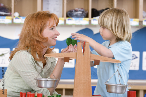 Photo: Teacher playing with boy (3-5), side view Teacher playing with boy (3-5), side view