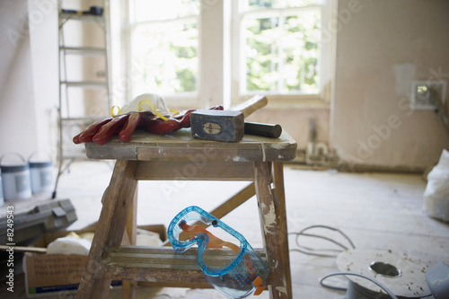 Photo: Various work tools on top of step ladder in undecorated room in house Various work tools on top of step ladder in undecorated room in house