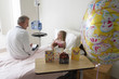 Photo: Girl (7-9) sitting in hospital bed, talking to doctor, balloon and cards in foreground, side view Girl (7-9) sitting in hospital bed, talking to doctor, balloon and cards in foreground, side view