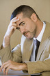 Photo: Stressed businessman tapping fingers on desk, leaning head on hand, side view, close-up, portrait Stressed businessman tapping fingers on desk, leaning head on hand, side view, close-up, portrait