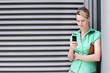 Photo: Young woman in green short-sleeved blouse text messaging on mobile phone Young woman in green short-sleeved blouse text messaging on mobile phone