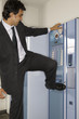 Businessman hitting a vending machine with his leg