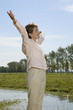 Woman Outdoors lifting arms up in freedom