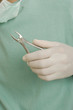 Mid section view of a dentist holding pliers