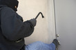 Burglar kicking door of house
