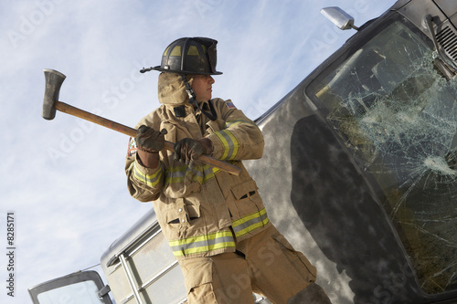 Photo: Firefighter hitting crashed car with axe Firefighter hitting crashed car with axe