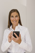 Photo: Portrait of a mid adult woman using a personal data assistant and smiling Portrait of a mid adult woman using a personal data assistant and smiling