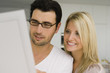 Foto: Close-up of a businessman with a businesswoman looking at a blueprint and smiling Close-up of a businessman with a businesswoman looking at a blueprint and smiling