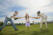 Family pulling arms of daughter