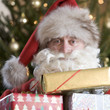 Father Christmas/Santa Claus holding a pile of presents