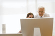 Businessman and a businesswoman looking at a computer monitor