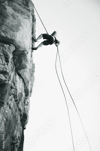 Photo: A climber climbing a rock face A climber climbing a rock face