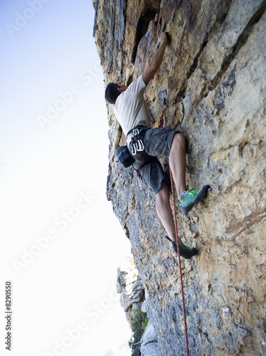 Photo: A climber climbing a rock face A climber climbing a rock face