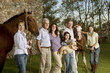 Three generation family portrait with horses and puppy