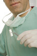 Mid section view of a dentist holding a plaque remover