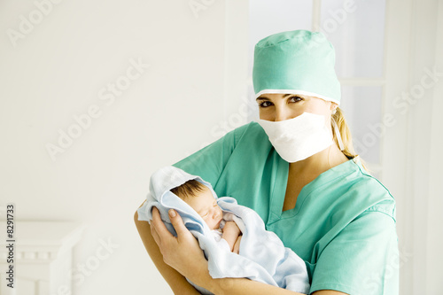 Photo: A medical practitioner holding a newborn baby A medical practitioner holding a newborn baby