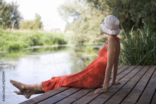 Photo: Young woman sitting by a river Young woman sitting by a river