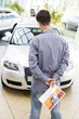A young man looking at a new car