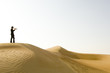 A young man standing in the desert with a loud hailer