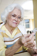 An elderly woman completing a jigsaw