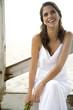 A bride sitting on a beach