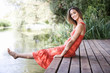 Young woman sitting by a river