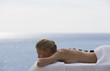 A young woman receiving a hot stone holistic treatment