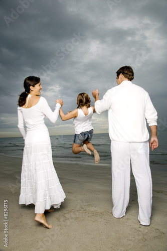 Photo: A couple with their daughter on a beach A couple with their daughter on a beach