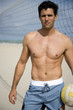 A young man playing beach volleyball