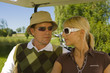 Close-up of a mid adult couple sitting in a golf cart