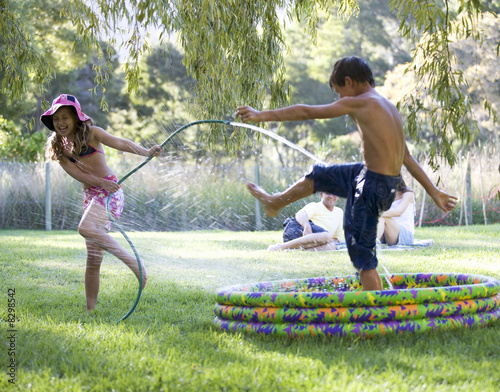 Foto: Young girl and boy playing in a paddling pool Young girl and boy playing in a paddling pool