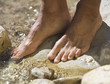 Close-up of feet in a stream
