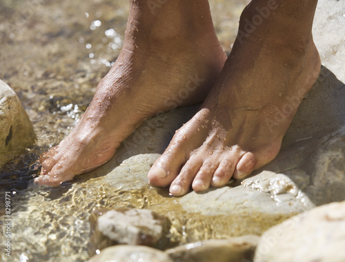 Photo: Close-up of feet in a stream Close-up of feet in a stream
