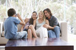 Foto: A young boy taking a photo of his family sitting on a sofa A young boy taking a photo of his family sitting on a sofa