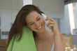 Woman drying her hair and phoning