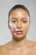 Portrait of a young woman with cake icing on her face