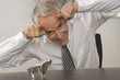 Businessman making horns gesture in front of a bull figurine and smiling
