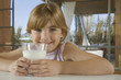 Happy young girl with glass of milk