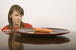 Young woman looking at carrot