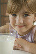 Happy young girl with glass of milk