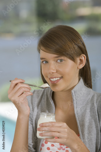 Photo: Young woman eating yogurt Young woman eating yogurt
