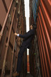 Side profile of a businessman climbing up on cargo containers