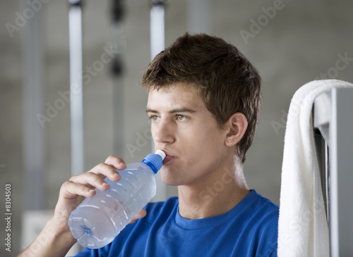 Photo: A young man drinking a bottle of water A young man drinking a bottle of water