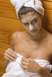 Close-up of a young woman with a facial mask applied on her face in a sauna