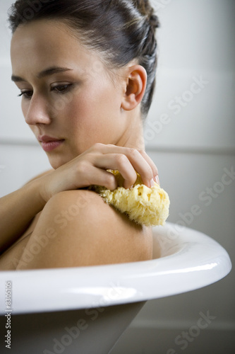 Photo: A young woman laying in a bath A young woman laying in a bath