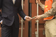 Mid section view of a businessman bribing a dock worker