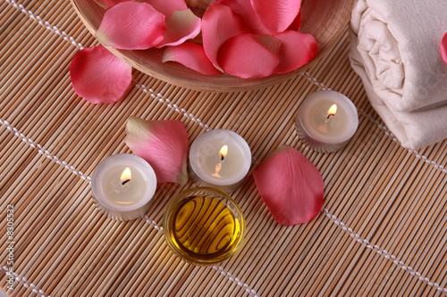 Photo: spa products with rose petals, oil container, towel and candles spa products with rose petals, oil container, towel and candles
