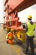 Rear view of a businessman with a male dock worker at a commercial dock